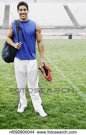 Male athlete smiling for the camera in football field View Large Photo Image Picture - Male athlete smiling for the camera in football field. Fotosearch