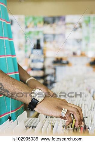 Stock Photograph - MAn browsing in a music store. Fotosearch