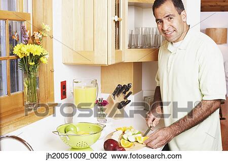 Man chopping fruit in the kitchen View Large Photo Image Stock Image - Man chopping fruit in the kitchen. Fotosearch