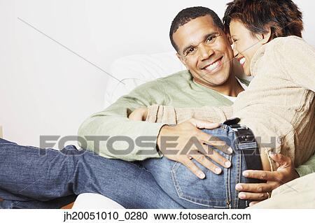 Stock Image - Man holding his girlfriend on his lap. Fotosearch