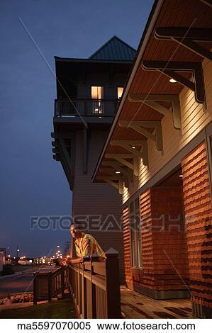 Man leaning over wooden banister View Large Photo Image Stock Photography - Man leaning over wooden banister. Fotosearch