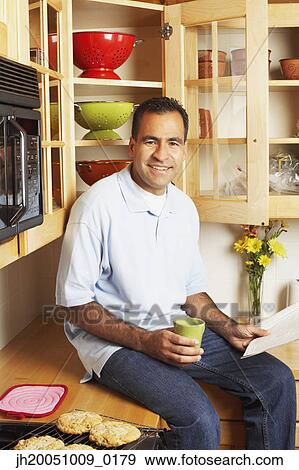 Man sitting on kitchen counter View Large Photo Image Stock Photo - Man sitting on kitchen counter. Fotosearch
