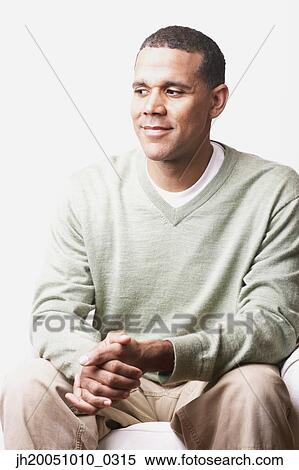 Man sitting on the couch View Large Photo Image Stock Photography - Man sitting on the couch. Fotosearch