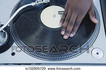 Stock Photo - Man spinning vinyl on a turntable. Fotosearch