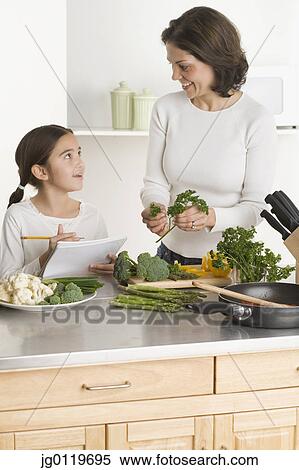 Stock Photography - Mother and daughter cooking together. Fotosearch