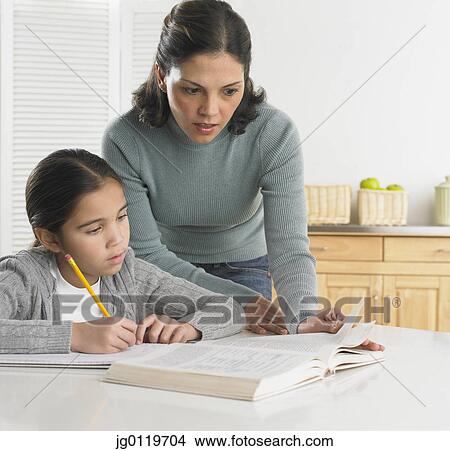 Picture - Mother helping her daughter with her homework. Fotosearch