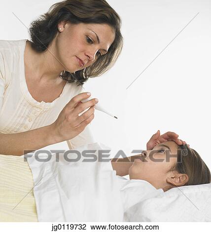 Stock Image - Mother taking her daughter's temperature. Fotosearch