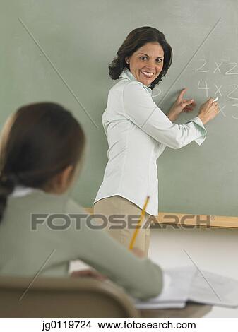 Teacher writing arithmetic on the blackboard View Large Photo Image Picture - Teacher writing arithmetic on the blackboard. Fotosearch
