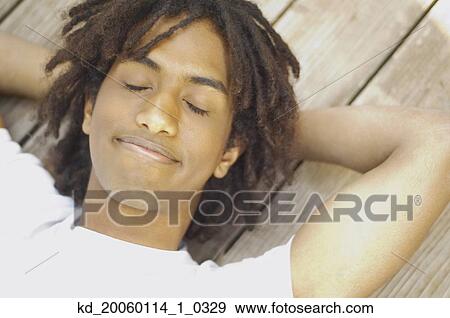 Stock Photo - Teenage boy asleep on wood. Fotosearch