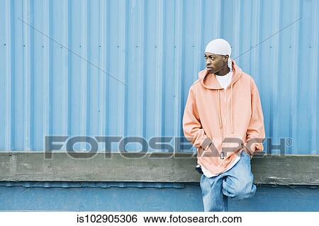 Stock Photograph - Teenage boy leaning against a wall. Fotosearch