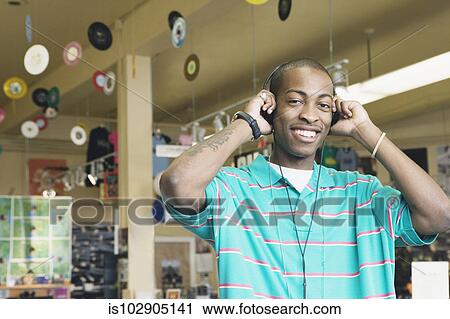 Teenage boy listening to headphones in a music store View Large Photo Image Stock Image - Teenage boy listening to headphones in a music store. Fotosearch