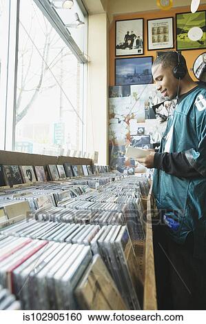 Teenage boy listening to headphones in a music store View Large Photo Image Stock Image - Teenage boy listening to headphones in a music store. Fotosearch
