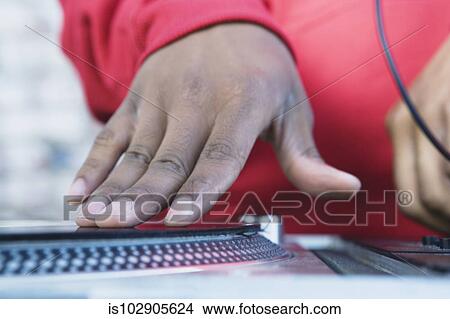 Picture - Teenage boy spinning vinyl on a turntable. Fotosearch