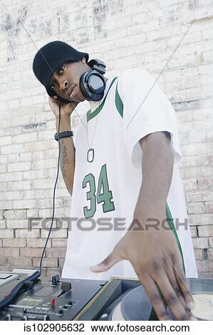Stock Image - Teenage boy using turntables and headphones. Fotosearch
