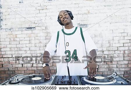 Stock Photo - Teenage boy using turntables and headphones. Fotosearch