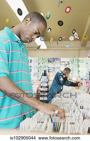 Picture - Teenage boys browsing in a music store. Fotosearch