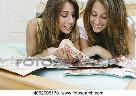 Stock Photo - Teenage girls reading a magazine together. Fotosearch