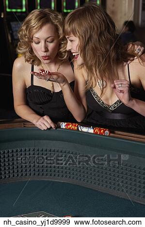 Woman blowing on dice for good luck in a casino View Large Photo Image Stock Photo - Woman blowing on dice for good luck in a casino. Fotosearch
