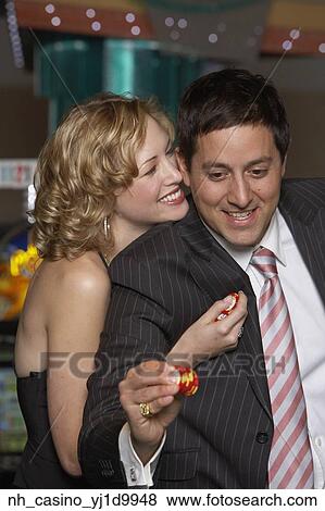 Stock Photo - Woman hugging her boyfriend at a casino. Fotosearch