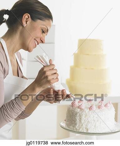 Woman icing a cake View Large Photo Image Stock Photo - Woman icing a cake. Fotosearch