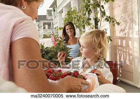 Woman offering strawberries to young child View Large Photo Image Stock Photography - Woman offering strawberries to young child. Fotosearch