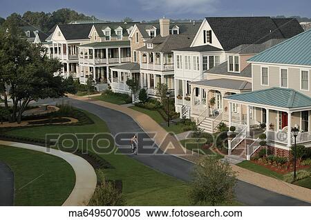 Stock Photography - Woman riding a bike down suburban street. Fotosearch
