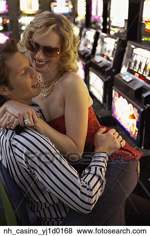 Woman sitting on her boyfriend's lap as they play the slot machines View Large Photo Image Stock Photo - Woman sitting on her boyfriend's lap as they play the slot machines. Fotosearch