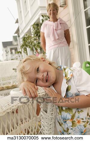 Stock Photography - Young boy leaning on wicker chair. Fotosearch