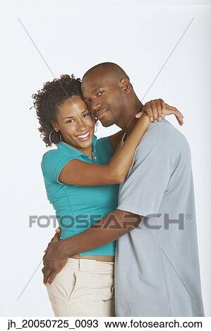 Young couple hugging and smiling for the camera View Large Photo Image Stock Image - Young couple hugging and smiling for the camera. Fotosearch