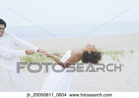 Young couple playing on the beach View Large Photo Image Picture - Young couple playing on the beach. Fotosearch