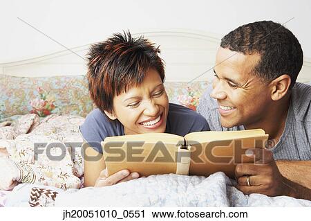 Young couple reading in bed View Large Photo Image Stock Image - Young couple reading in bed. Fotosearch