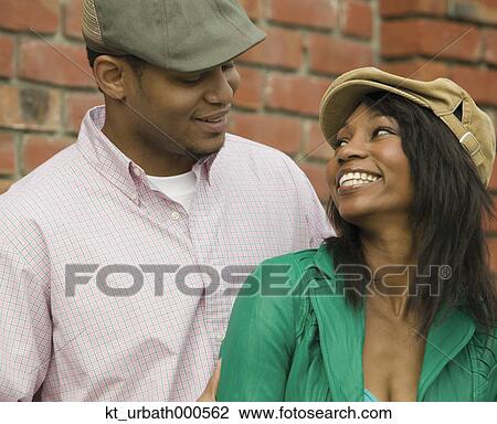 Stock Image - Young couple smiling at each other. Fotosearch