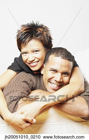 Stock Image - Young couple smiling for the camera. Fotosearch