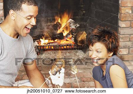 Young couple toasting marshmallows View Large Photo Image Stock Photo - Young couple toasting marshmallows. Fotosearch