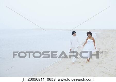 Young couple walking on the beach View Large Photo Image Stock Image - Young couple walking on the beach. Fotosearch