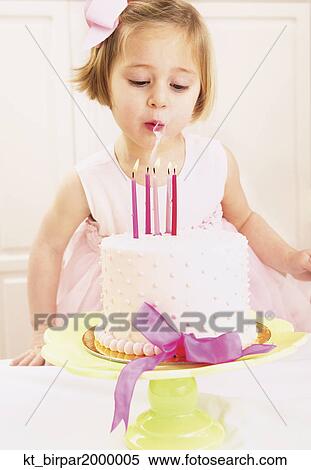 Young girl blowing out the candles on a birthday cake View Large Photo Image Stock Photography - Young girl blowing out the candles on a birthday cake. Fotosearch