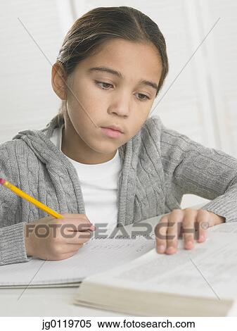 Stock Photography - Young girl doing her homework. Fotosearch