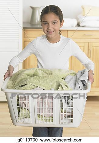 Stock Image - Young girl holding a laundry basket. Fotosearch