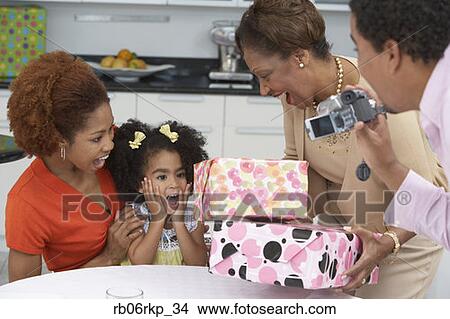 Picture - Young girl receiving birthday presents. Fotosearch