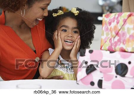 Stock Photograph - Young girl receiving birthday presents. Fotosearch