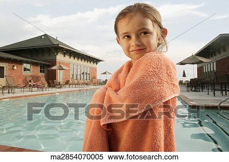 Stock Photography - Young girl wrapped in a towel by swimming pool. Fotosearch