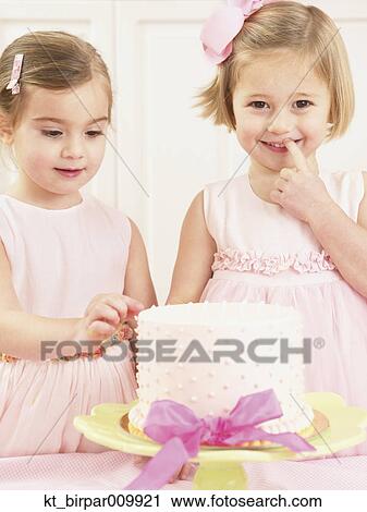 Young girls picking at a birthday cake View Large Photo Image Stock Image - Young girls picking at a birthday cake. Fotosearch