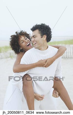 Young man carrying his girlfriend on his back View Large Photo Image Picture - Young man carrying his girlfriend on his back. Fotosearch
