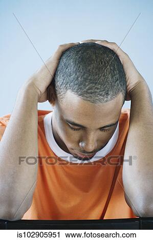 Young man holding his head in his hands View Large Photo Image Stock Image - Young man holding his head in his hands. Fotosearch