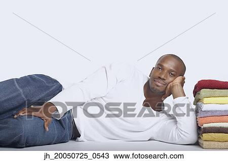 Young man posing with a stack of folded towels View Large Photo Image Stock Image - Young man posing with a stack of folded towels. Fotosearch