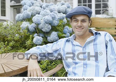 Young man relaxing in a lawn chair View Large Photo Image Picture - Young man relaxing in a lawn chair. Fotosearch