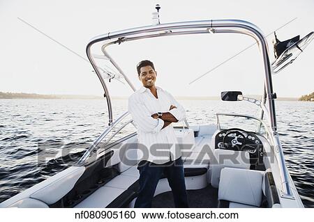 Young man smiling in a boat View Large Photo Image Stock Image - Young man smiling in a boat. Fotosearch