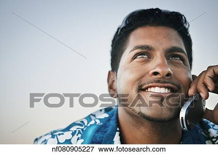 Young man talking on his cell phone View Large Photo Image Stock Photo - Young man talking on his cell phone. Fotosearch