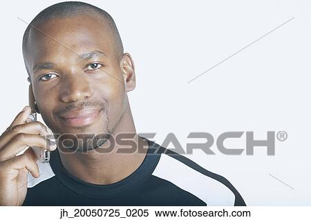 Young man talking on his cell phone View Large Photo Image Stock Photography - Young man talking on his cell phone. Fotosearch