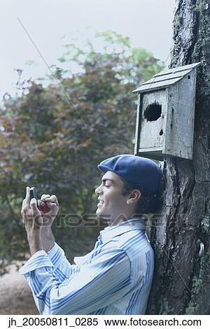 Young man using a PDA outdoors View Large Photo Image Stock Photography - Young man using a PDA outdoors. Fotosearch